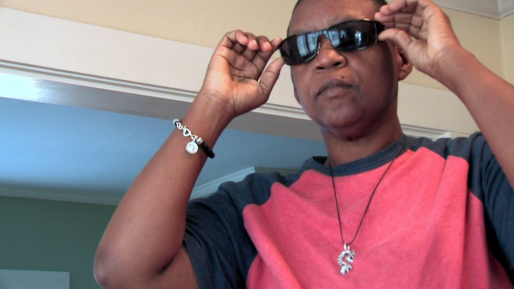 African American butch lesbian puts on sunglasses