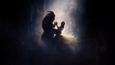 A dark image with a large beastlike creature dancing with a smaller woman in sillouette under a spotlight and in a smoky space.