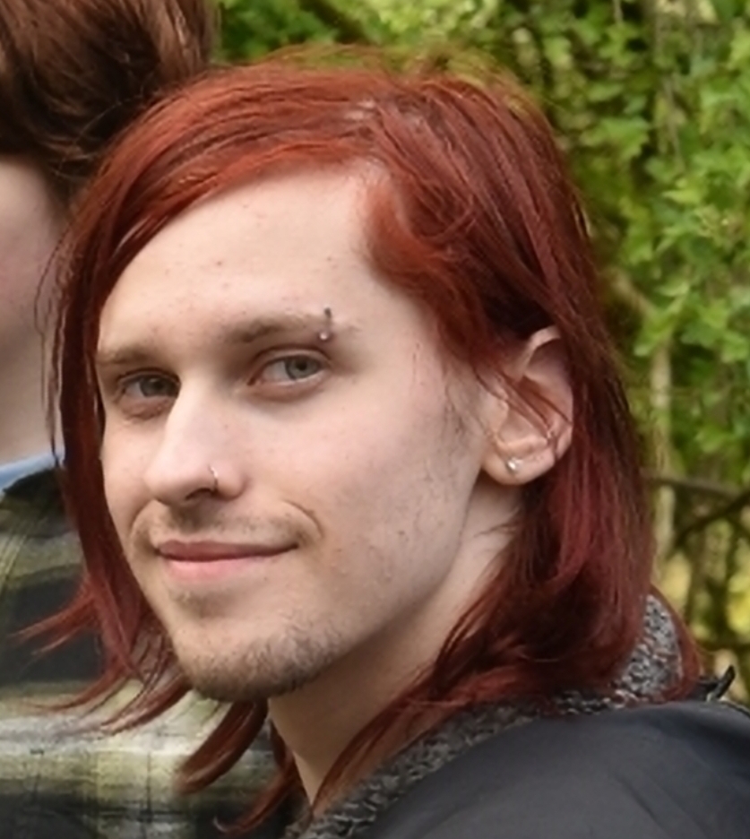 Red haired person smiling at camera