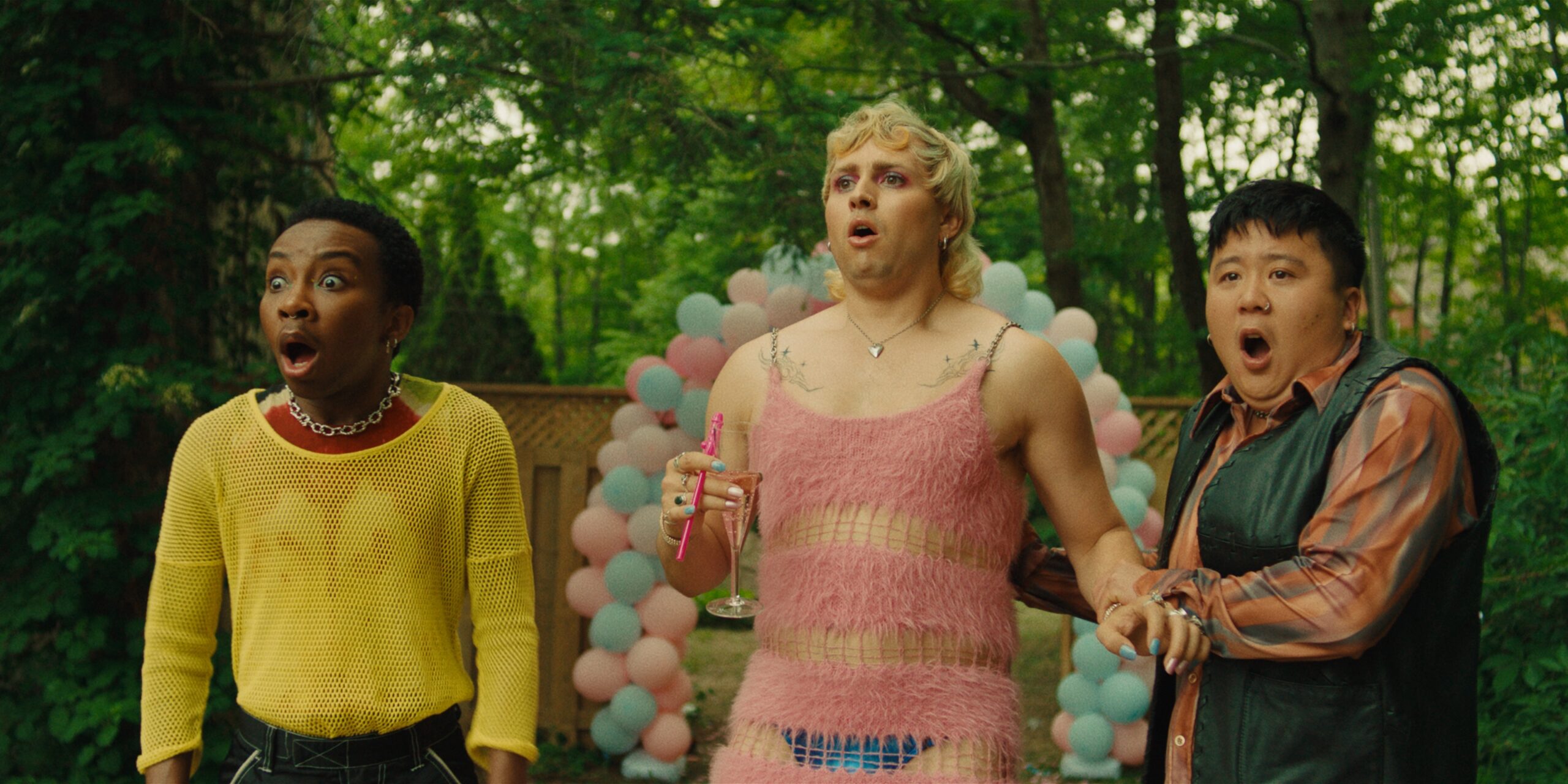 Three colourfully dressed queer people look surprised.