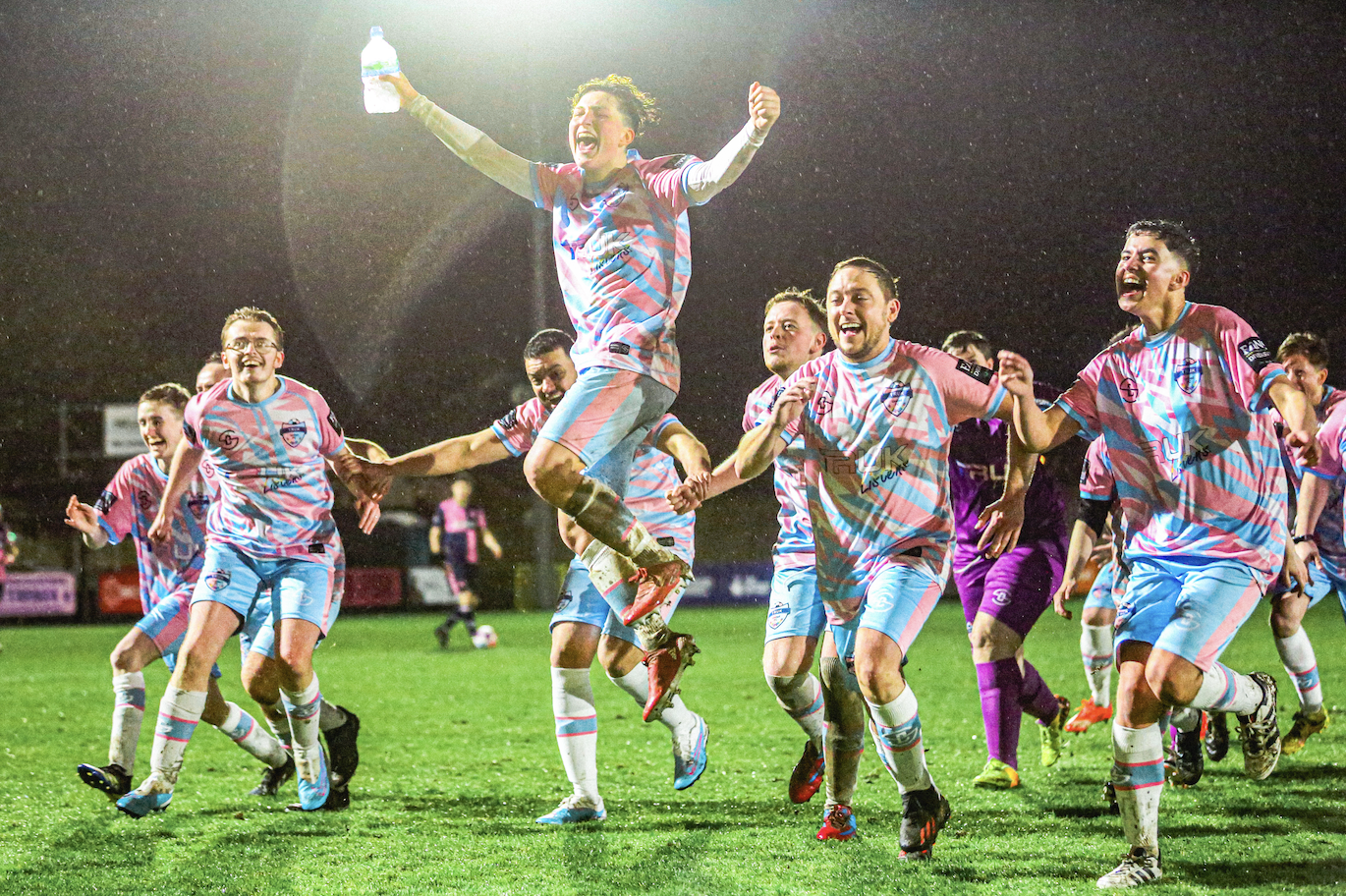 Screenshot 2025-09-08 at 15.50.44 Footballers wearing trans coloured sports clothes embrace each other in celebration.