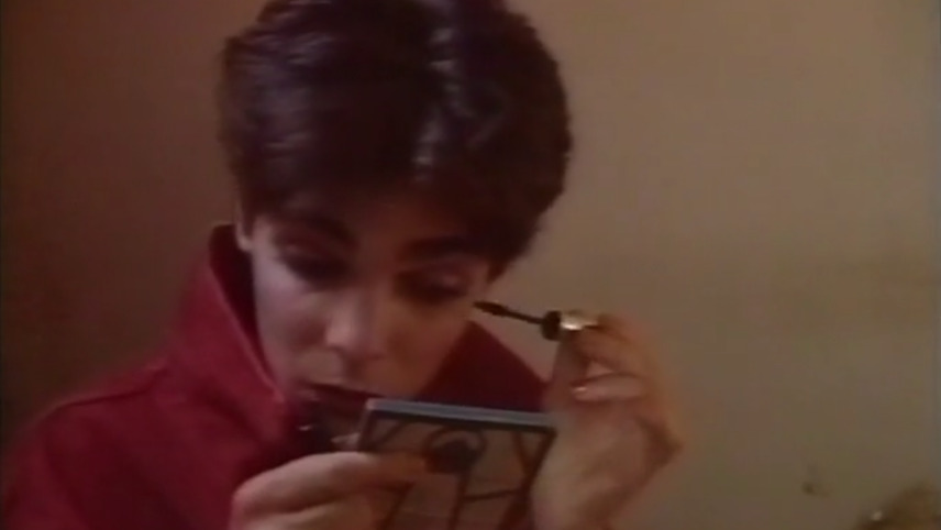 Woman putting on mascara.